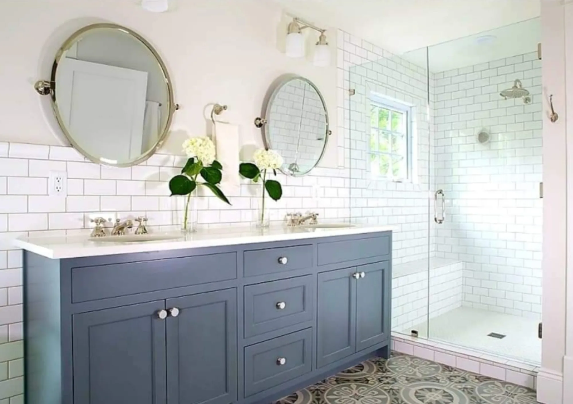 Bathroom remodel with blue cabinetry, subway tile, and a frameless glass shower
