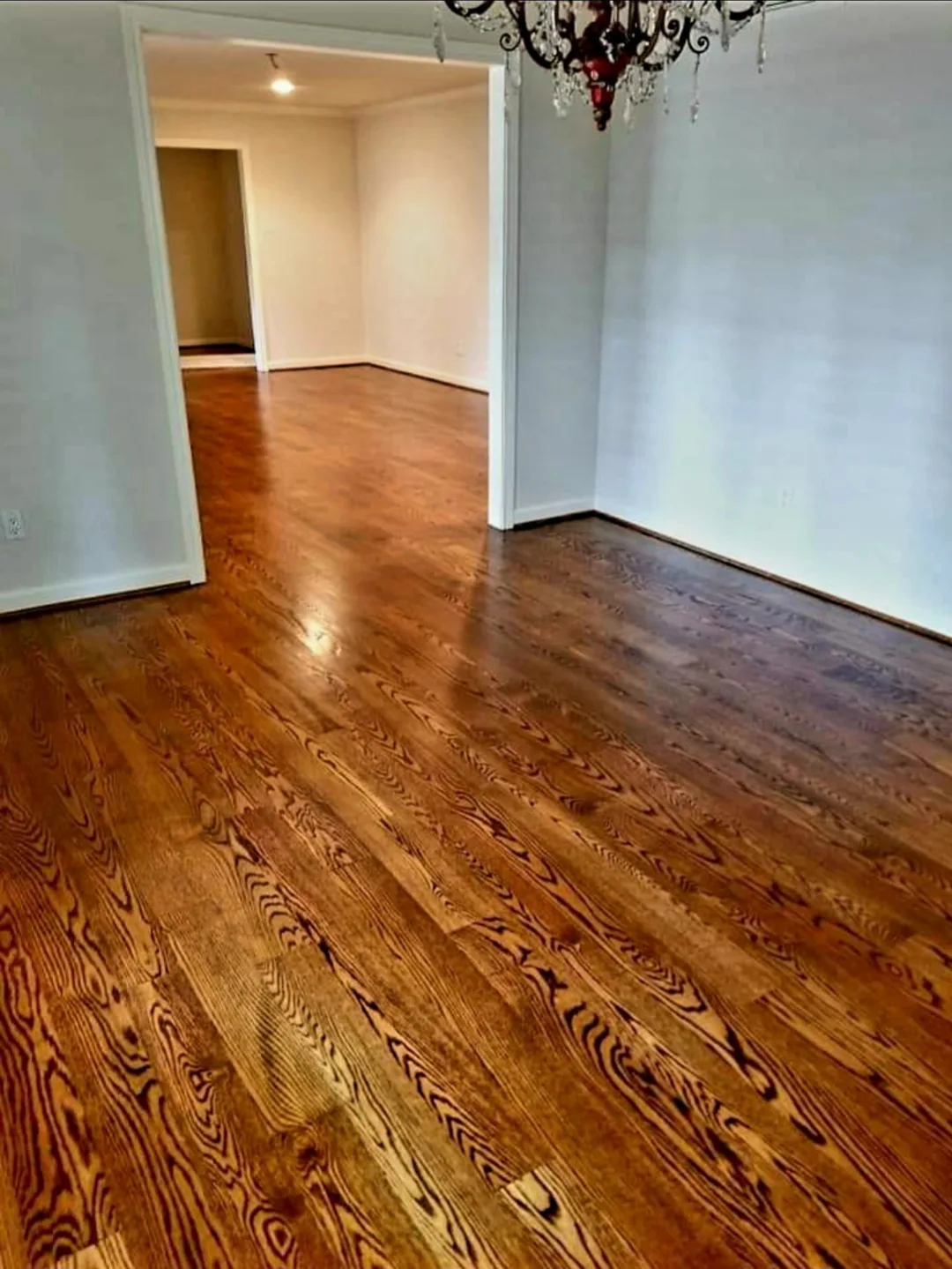 Refinished hardwood flooring through hallway and adjoining room